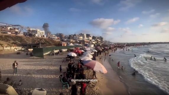 Gazze'de, şehrin üzerinde dumanlar yükselirken sahildeki insanlar: Sosyal medyada paylaşılan video
