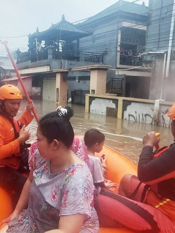 Torrential rain turns Bali's streets into rivers, and cars drift away.