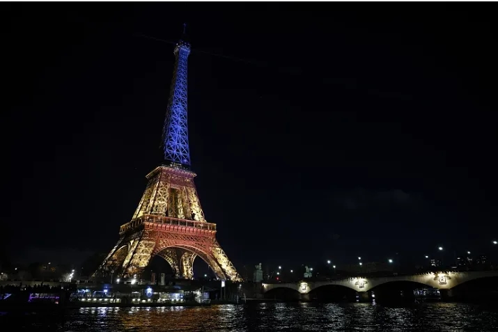 Cientos de personas se reunieron cerca de la Torre Eiffel iluminada con los colores del país